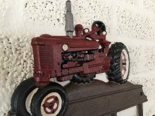 Farmhouse design coat rack with Farsnall agricultural tractor.